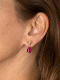 Rubelite faceted oval drop earring in 18k yellow gold vine with diamond ear wire.