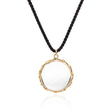 Rock crystal "looking glass" pendant in 18k yellow gold vine on black silk cord.