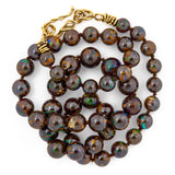 Round boulder opal bead necklace with an 18k yellow gold vine clasp.